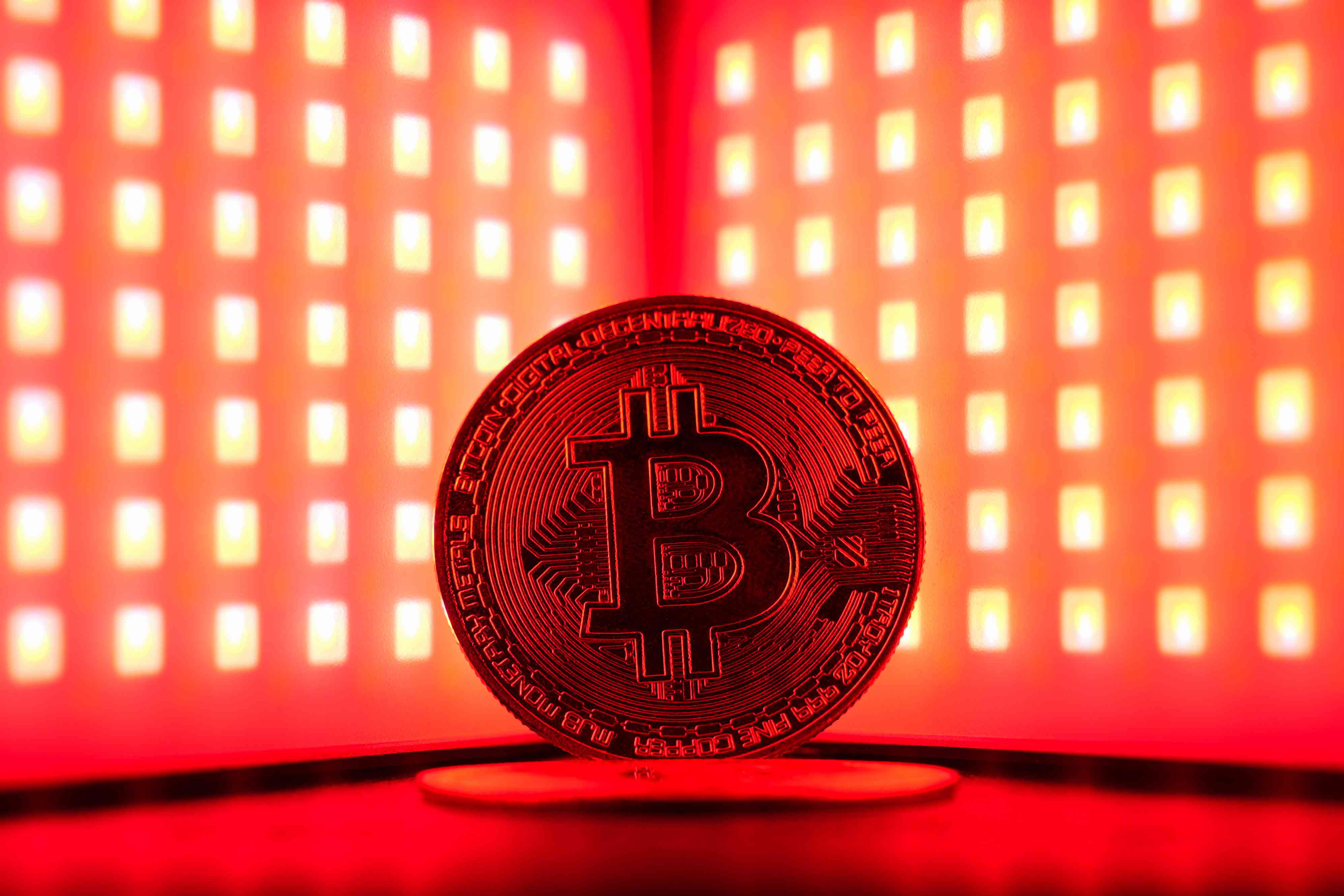 Symbolic photo of bitcoin in red light